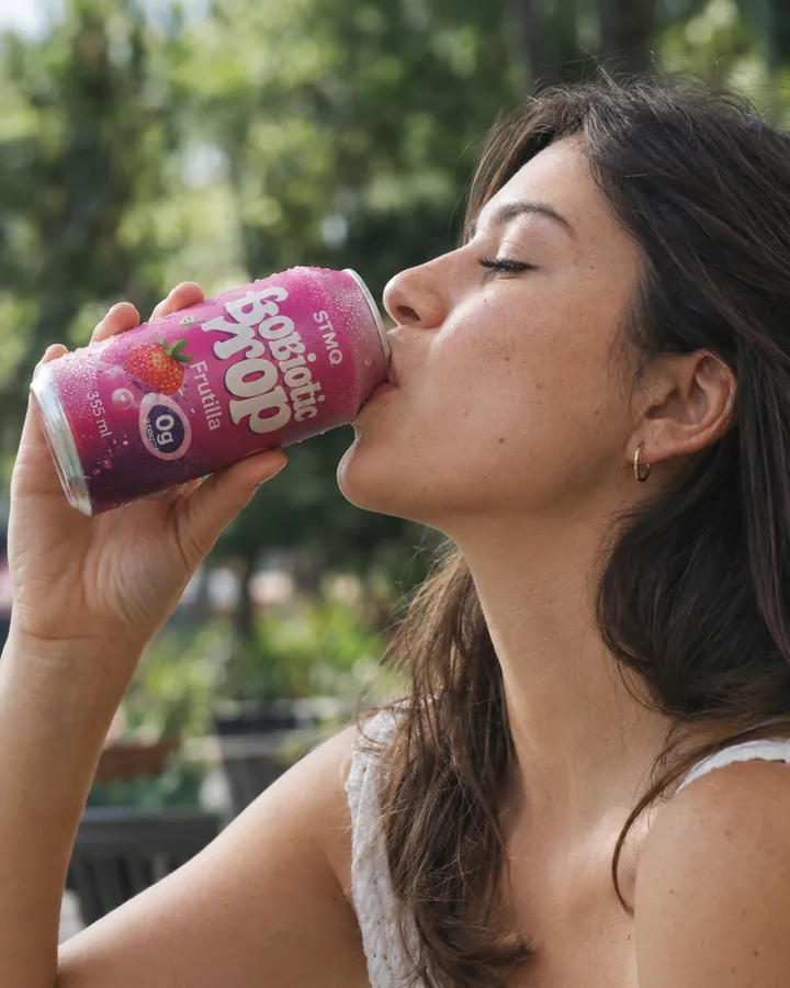 Chica tomando Probiotic Pop de frutilla